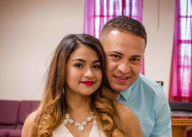 A young Bride and Groom smiling at the camera on their Elopement Day.