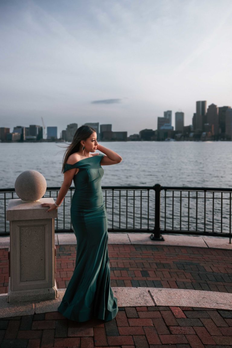 Portrait of a young lady in a long green dress looking into the distance.
