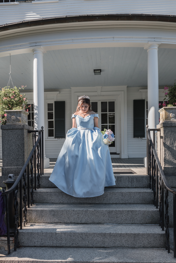 Smiling teenager with a princess dress walking down stone steps